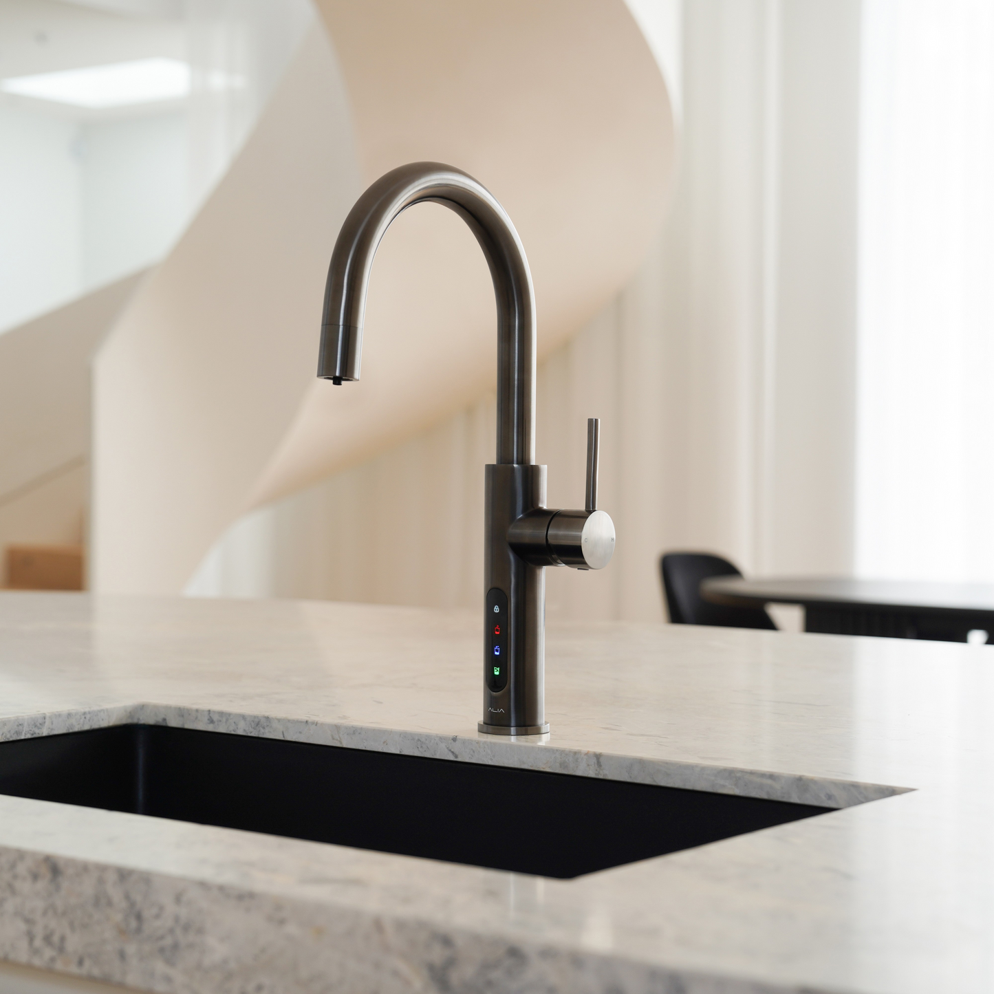 Alia X51 instant hot, cold, and sparkling filtered water tap in gunmetal grey finish showcased in a contemporary kitchen, providing filtered water with a bold modern style.
